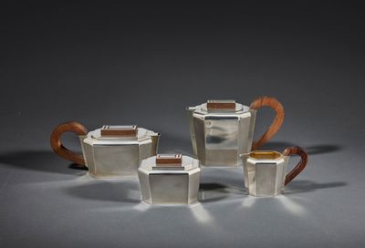 un service à thé et à café en argent composé de trois pièces, posé sur un support gris