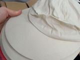 a person holding a white hat with a red band