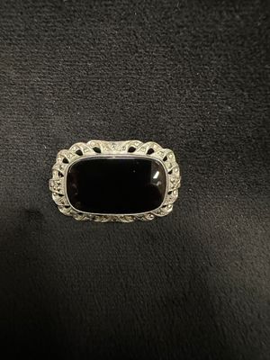 a black stone ring sitting on top of a black leather surface
