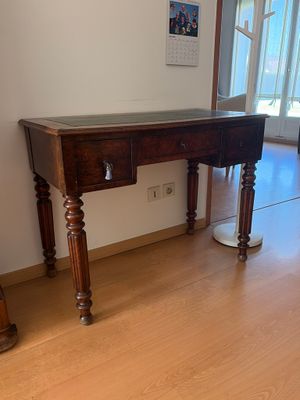 une table en bois avec un plateau en verre, dans un coin de la pièce