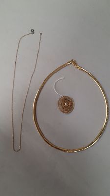 Deux bijoux sont posés sur une surface blanche.