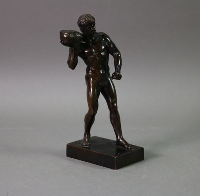 statue en bronze représentant un homme tenant un ballon de football, posée sur un socle en marbre