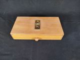 a small wooden box with a metal handle on a black background