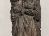 an old statue of a woman holding a child on a table