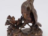 an image of a bronze statue of a pheasant on a rock