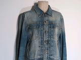 une veste en jean posée sur un mannequin, lui-même placé sur un support pour mannequin