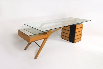 une photo d'un bureau avec un plateau en verre et des pieds en bois