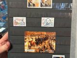 a person holding up a book with stamps on it