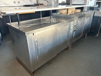 un grand comptoir en acier inoxydable au milieu d'une pièce