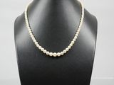un collier de perles blanches sur un mannequin noir