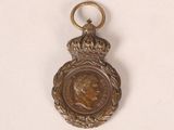 an old bronze medal with a crown on top of it