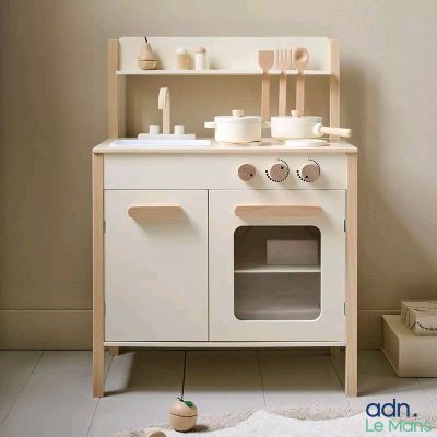 a white wooden toy kitchen with a stove and sink