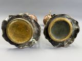 pair of bronze and green glass vases on a white surface