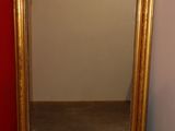 a mirror that is sitting on the floor in front of a red wall