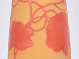 a yellow and red vase sitting on a white surface