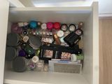 une étagère blanche sur laquelle sont disposés de nombreux produits de beauté et autres articles