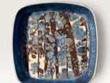 a blue and white plate with a tree design on it