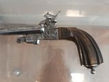 a silver gun that is on display in a glass case