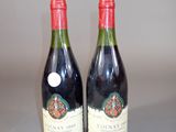 two bottles of wine sitting on top of a table next to each other