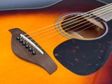 an image of a close up of an acoustic guitar with strings