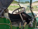an old green car with a steering wheel and a steering stick