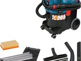 the vacuum is blue and has a cleaning kit on top of it