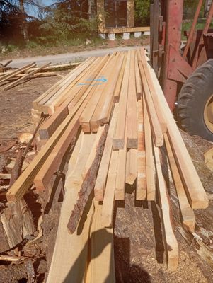 un gros tas de bois posé par terre à côté d'un tracteur