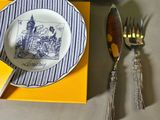 a plate with a blue and white design on it next to a fork and knife