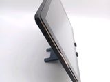 a tablet computer sitting on a stand on a white surface