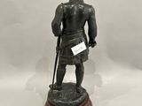 une image représentant une statue d'un homme en armure, l'épée à la main