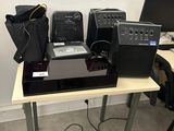 a table with a laptop, speakers, and other electronics on it