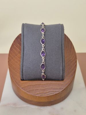 bracelet with amethorate and diamonds on display on a wooden stand