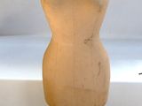 a mannequin on a wooden stand in front of a window