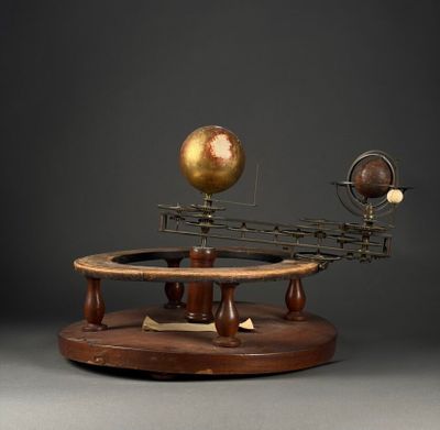 an image of a model of the solar system on a wooden stand