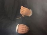 portrait of a man in a black coat and white shirt holding a chain