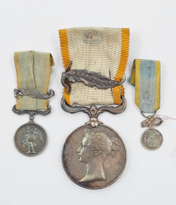 deux médailles et une médaille sont posées sur une surface blanche