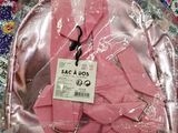 a pink backpack that is wrapped in plastic on a table
