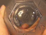 a person holding a clear glass object in their hand