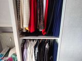 une armoire avec beaucoup de vêtements suspendus dedans