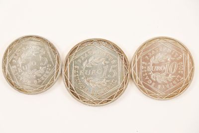 three different british coins are shown in a row on a white surface
