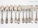 a lot of silver spoons and forks on a table