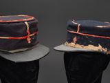 pair of hats on mannequin heads on a black background