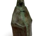 an image of a bronze statue of a woman sitting on a rock