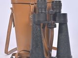 a brown bag and a pair of binoculars on a white surface