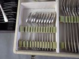 many forks and spoons in a box on the table