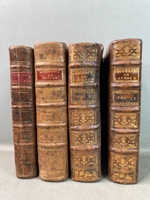 Quatre vieux livres sont alignés sur une table