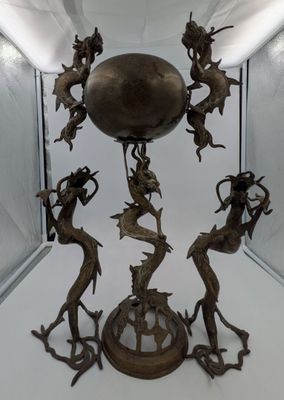 a bronze sculpture of a group of mermaids on a pedestal
