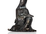 l'image d'une statue de femme assise sur un rocher