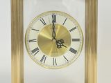 une horloge en or avec des chiffres romains sur le cadran