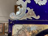a blue glass clock with a decorative design on top of it